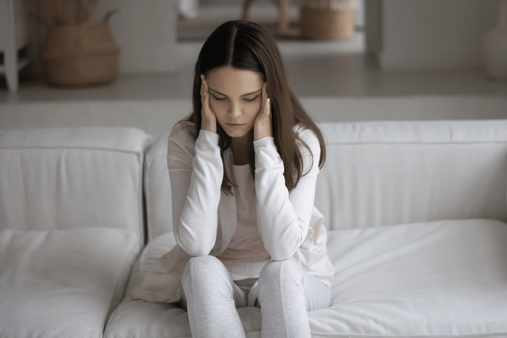 Girl siting on a couch in a depressed state