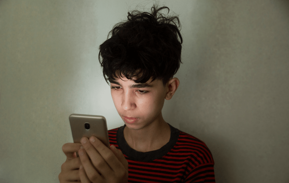 Boy staring at cell phone