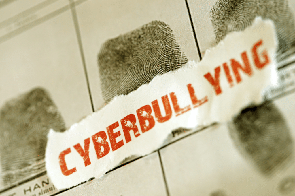 The word "cyberbullying" on a piece of paper with fingerprints