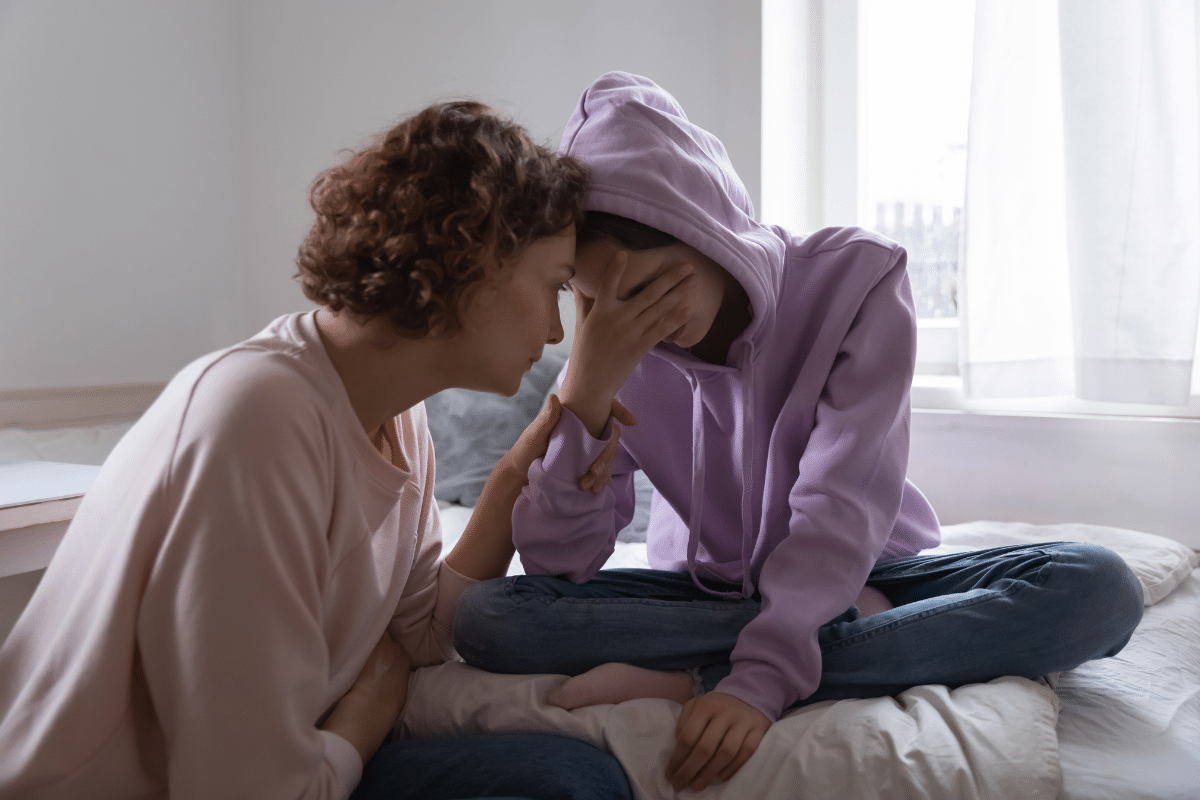 mother comforting upset teen daughter