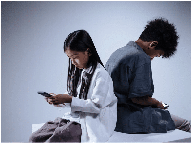 Two kids both using smartphones