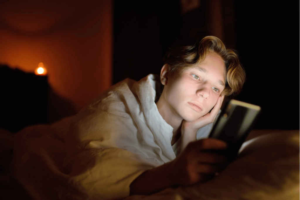 Teen using smartphone at night