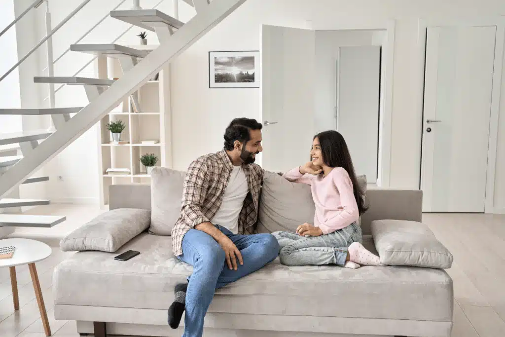 a dad and daughter sitting on a couch