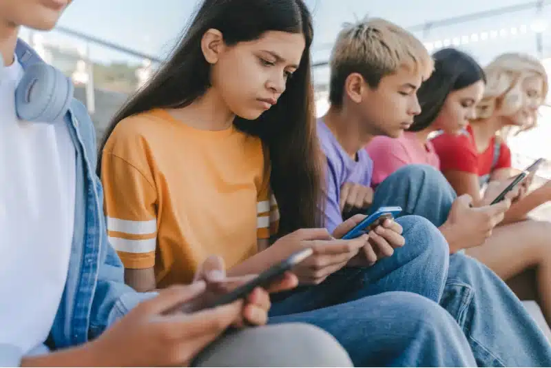 a girl and her friends using social media on their phones