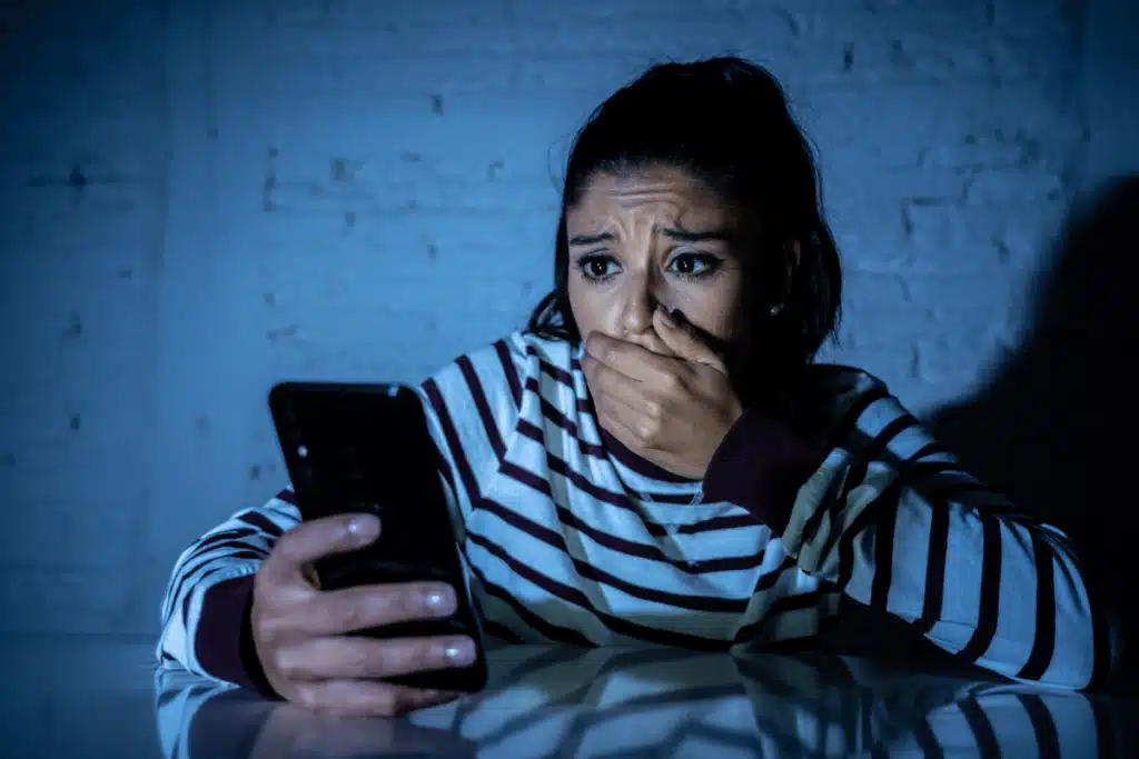 a cyberstalking victim looks at their phone