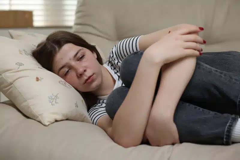 a young girl laying down on a couch