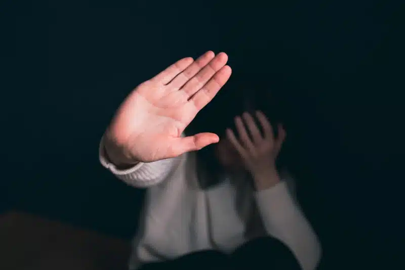 a young teen holding their hand up