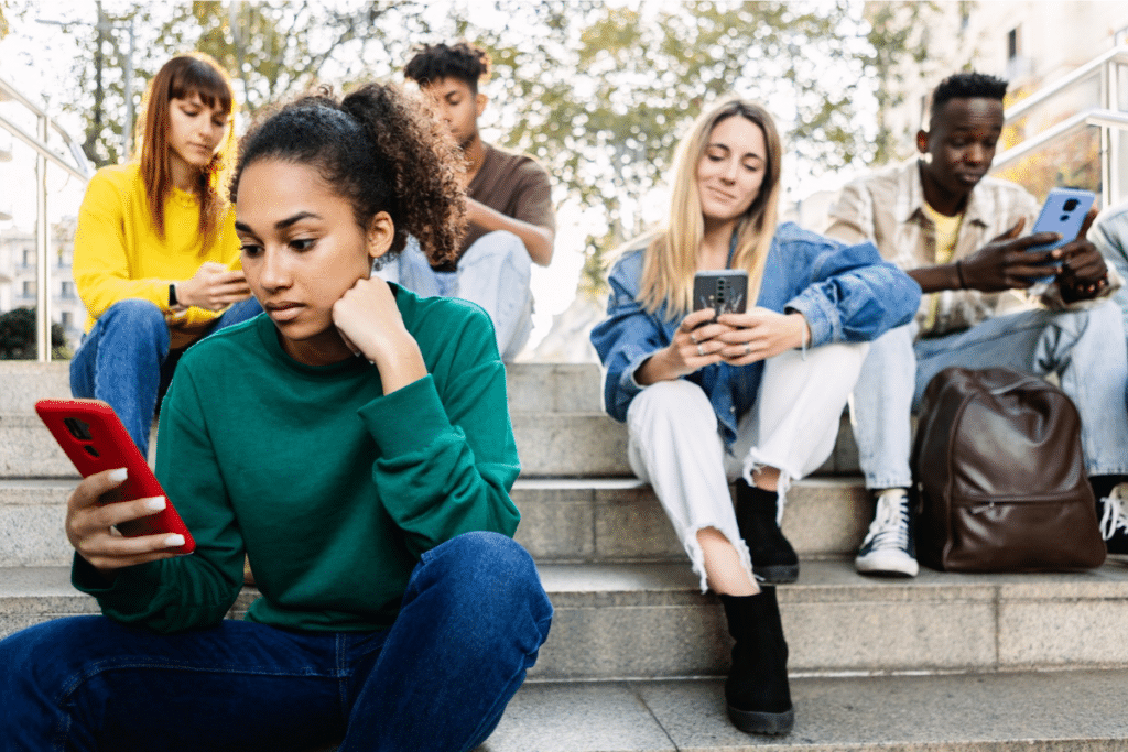 a group of teens scrolling on social media on their phones